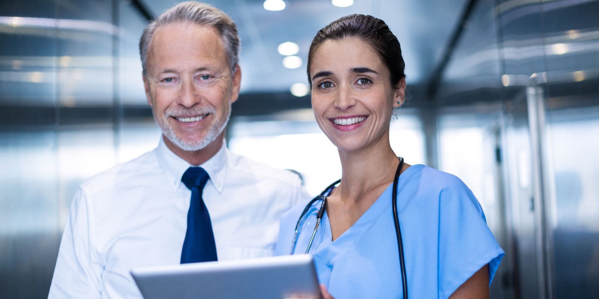 Physician and nurse reviewing patient records on a tablet, HIPAA compliance consulting