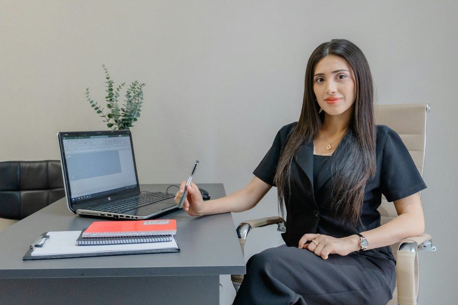 Professional reviewing domain email settings at a laptop in a bright office
