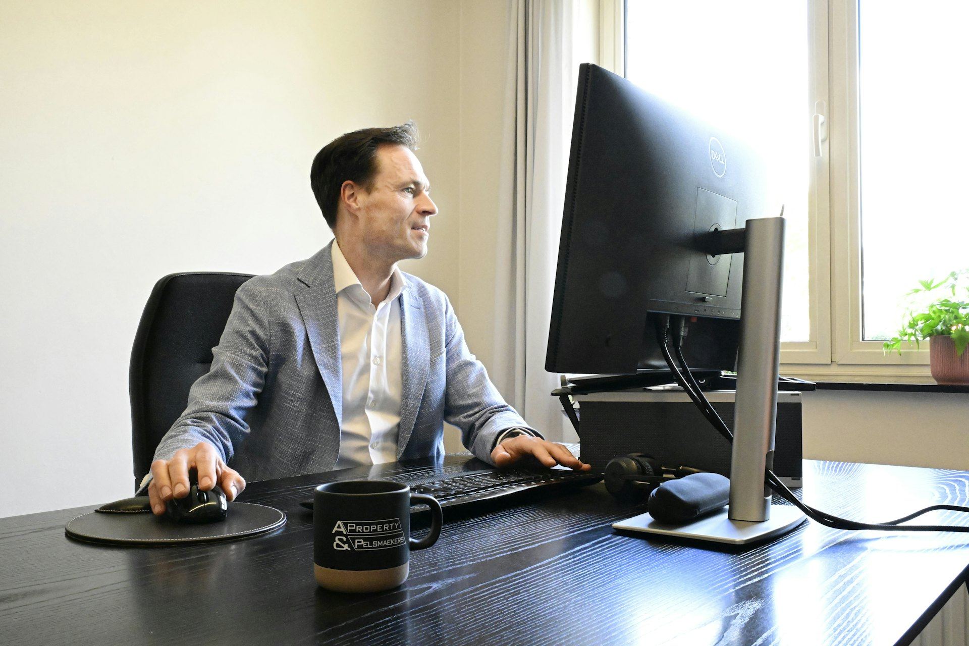 Business professional in a blazer reviewing Microsoft 365 security settings at his desk