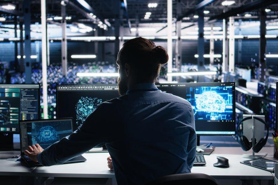 IT administrator at a workstation in a data center reviewing systems that hold personal information