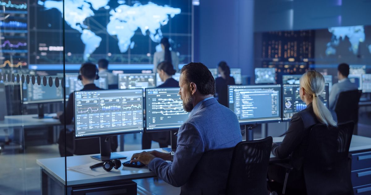 The Cybersecurity Executive Summary Every CEO and IT Manager Should See 3 Operations staff monitoring screens in a control room, illustrating the Collins Aerospace ransomware attack on airport systems