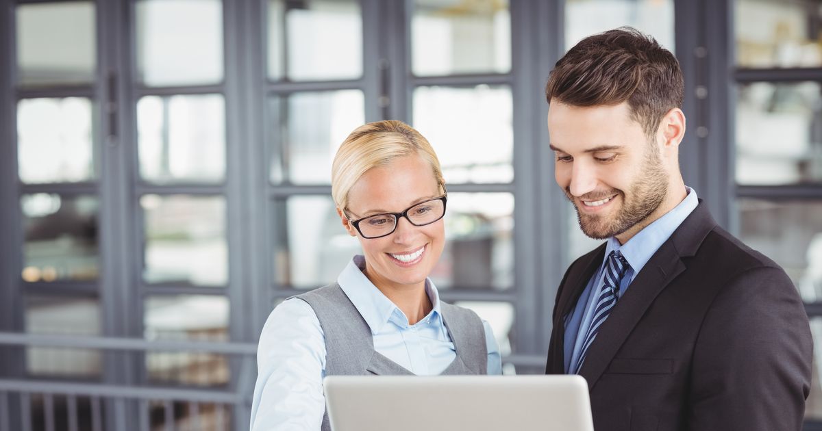 The Cybersecurity Executive Summary Every CEO and IT Manager Should See 1 Two IT professionals reviewing a laptop in a data center, illustrating a review of cyberattacks in 2026
