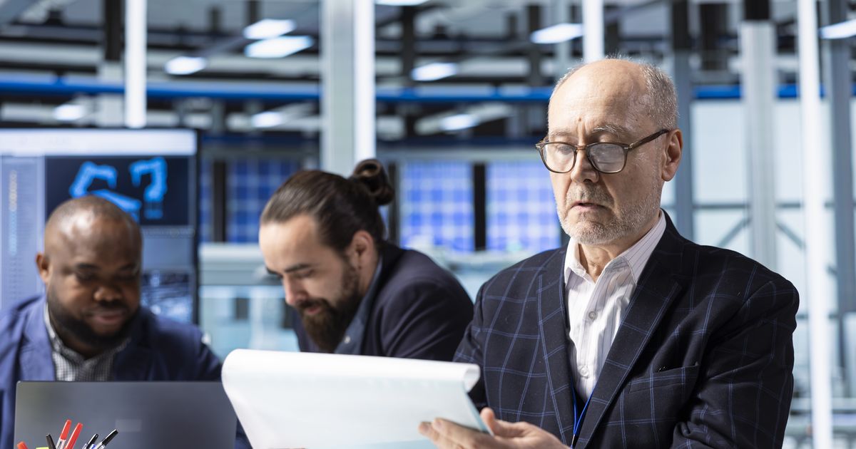 Manufacturing managers reviewing documents in an industrial plant, illustrating the Jaguar Land Rover cyberattack