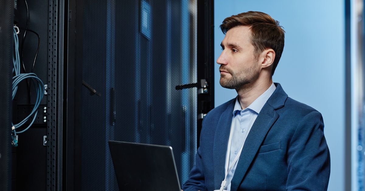 The Cybersecurity Executive Summary Every CEO and IT Manager Should See 6 Network engineer working on a laptop beside a server rack, illustrating the Snowflake customer breaches